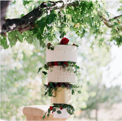 A wedding cake suspended from a tree