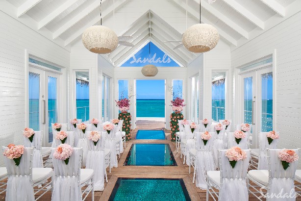 An overwater wedding chapel with a glass aisle above the sea