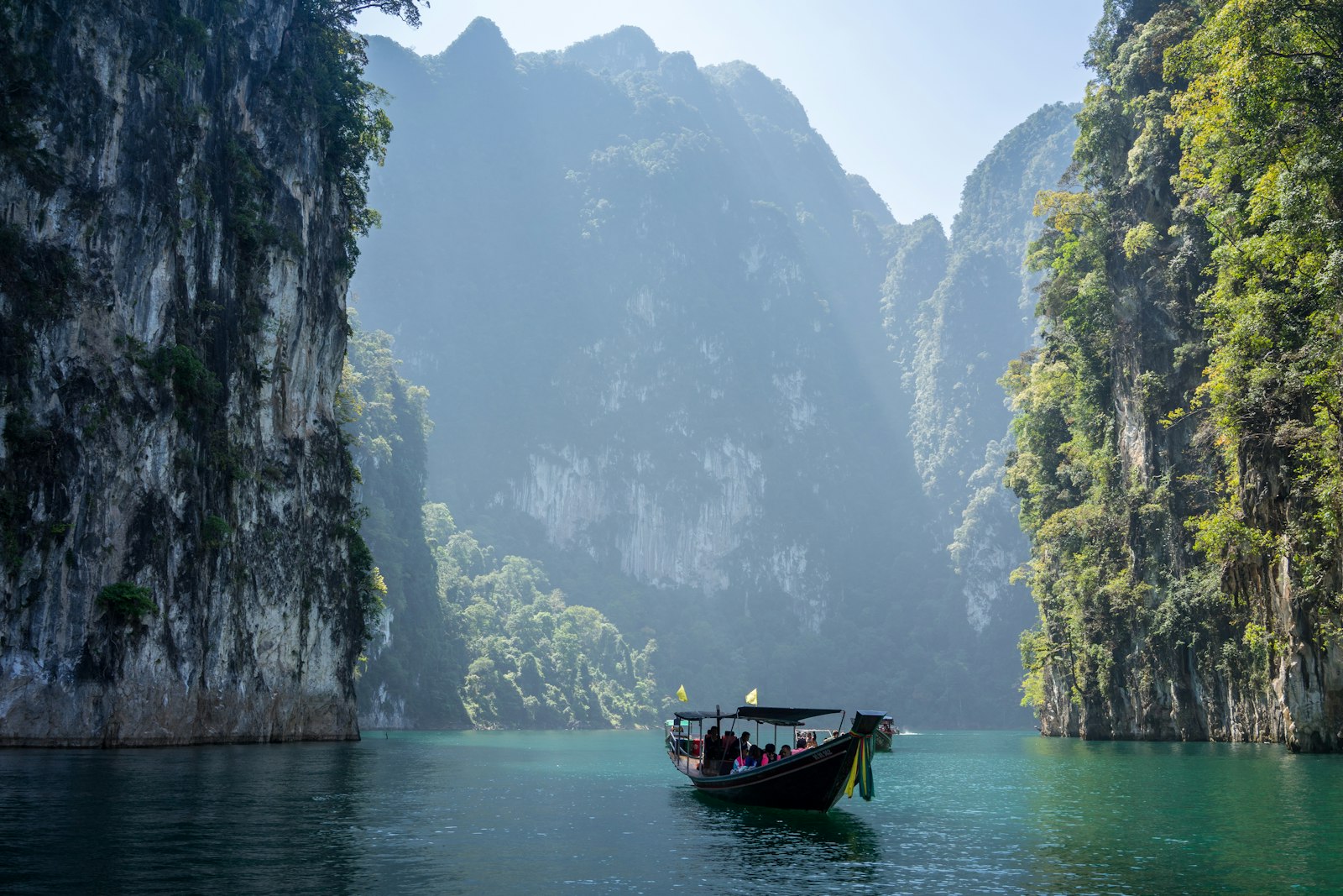 A private longtail boat gliding between limestone karsts